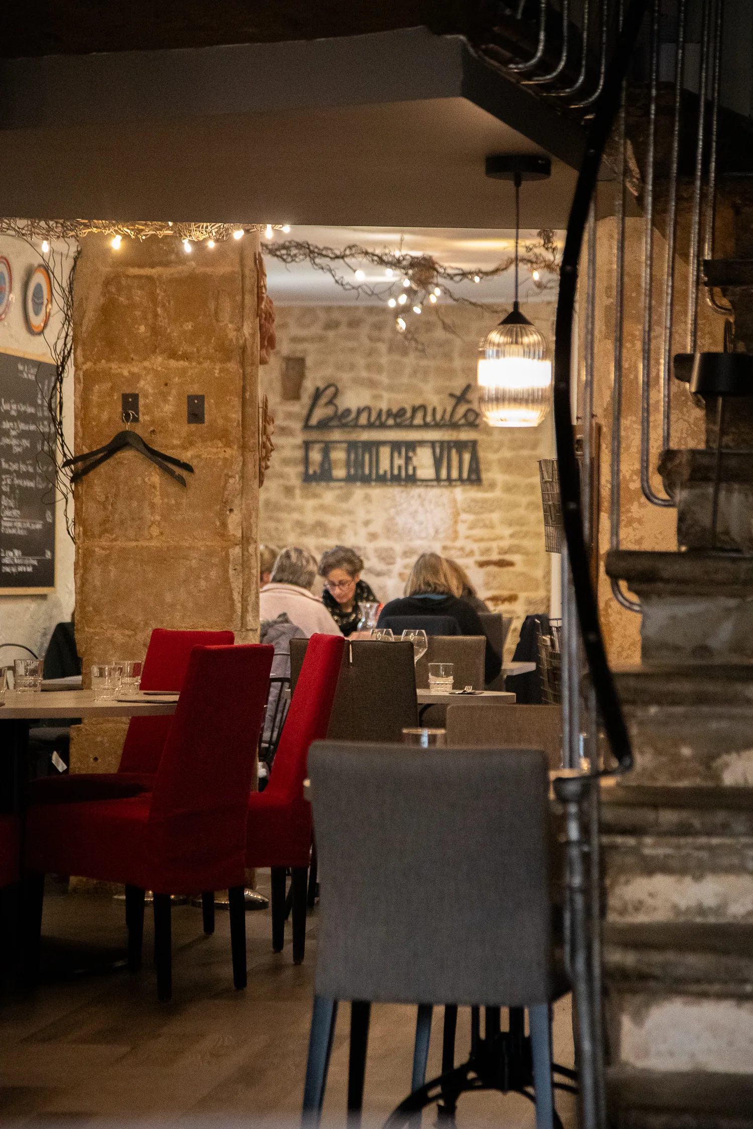 Salle du restaurant, murs en pierre et banquettes rouges